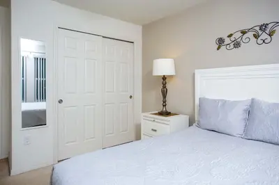 a white bedroom with a bed and a lamp at Family Friendly 4 Bedrooms with GameRoom close to Disney in Compass Bay 5103 in Kissimmee