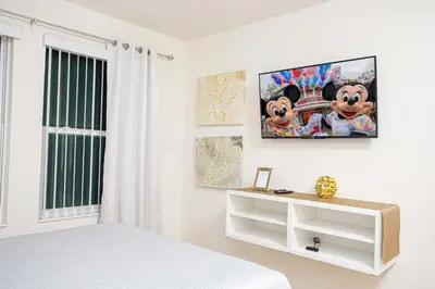 a bedroom with a mickey mouse poster on the wall at Family Friendly 4 Bedrooms with GameRoom close to Disney in Compass Bay 5103 in Kissimmee
