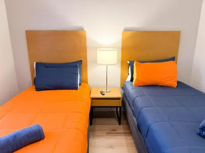 two beds with orange and blue pillows in a room at ER3047WOR - Cozy 3BD Townhome w/ Private Hot Tub in Kissimmee