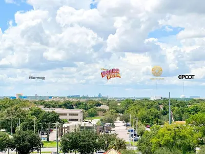 two large signs flying in the sky over a parking lot at BHBR207 - Condo Close to Disney - 1 mile in Orlando