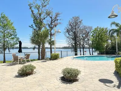 a swimming pool with a table and chairs next to the water at BHBR207 - Condo Close to Disney - 1 mile in Orlando