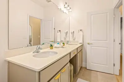 a bathroom with a sink and a large mirror at Casa 5Q Moderna c/ Piscina – 15min Disney in Orlando