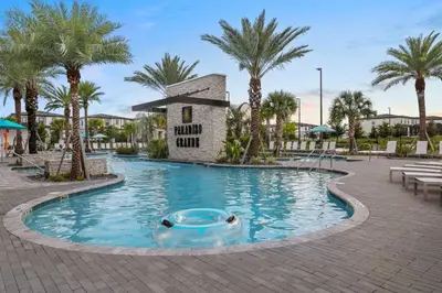 a swimming pool at a resort with palm trees at Casa 5Q Moderna c/ Piscina – 15min Disney in Orlando