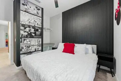 a bedroom with a white bed with a red pillow at Paradiso Grande 5Q c Piscina e Quartos Temáticos in Orlando