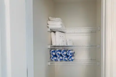 a closet with towels and blue and white towels at Modern Pool Townhome Minutes to Disney in Kissimmee