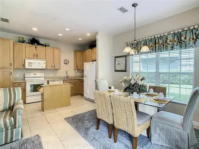 a kitchen and dining room with a table and chairs at Coral Cay Resort Your home away from home! in Kissimmee