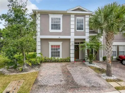 a house with a palm tree in front of it at Coral Cay Resort Your home away from home! in Kissimmee