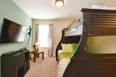 a bedroom with a bunk bed and a flat screen tv at Florida Dreaming home in Kissimmee