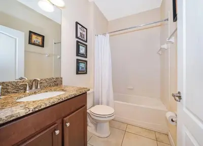 a bathroom with a sink and a toilet and a tub at Florida Dreaming home in Kissimmee