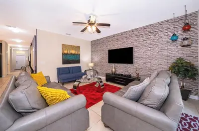 a living room with couches and a brick wall at Florida Dreaming home in Kissimmee