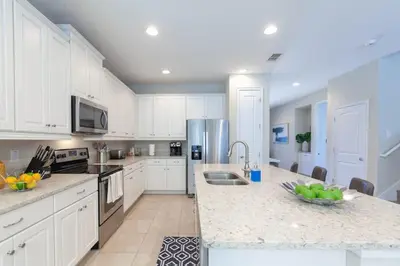 a kitchen with white cabinets and a counter top at Incredible 8BR PetFriendly Encore Resort next to Disney - 7474 in Orlando