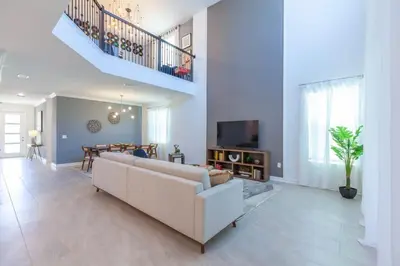a living room with a white couch and a table at Gorgeous 5BR at Storey Lake next to Disney - 2924 in Kissimmee