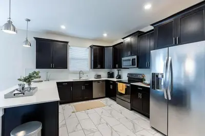 a kitchen with black cabinets and a stainless steel refrigerator at Stunning 6BR Lakeview at Storey Lake next to Disney - 2929 in Kissimmee