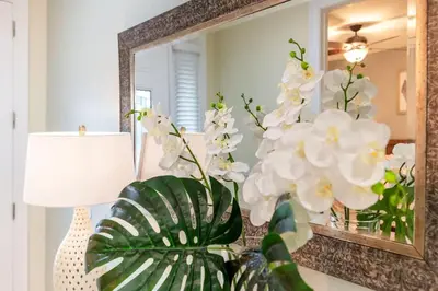 a mirror and some white flowers in a room at Gorgeous 8BR PetFriendly at Encore Resort next to Disney - 7625 in Orlando