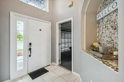a hallway with a white door and a tile floor at Lake Berkley 5Q, Piscina Aquecida, Perto Disney in Kissimmee
