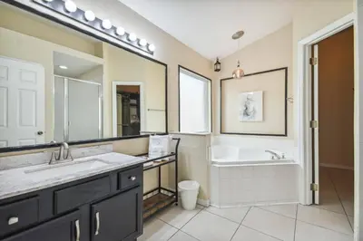 a bathroom with a tub and a sink and a bath tub at Lake Berkley 5Q, Piscina Aquecida, Perto Disney in Kissimmee