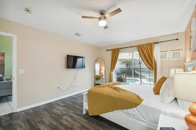 a bedroom with a bed and a flat screen tv at Lake Berkley 5Q, Piscina Aquecida, Perto Disney in Kissimmee