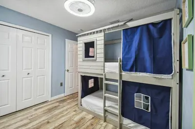 a bunk bed in a room with blue walls at Lake Berkley 5Q, Piscina Aquecida, Perto Disney in Kissimmee