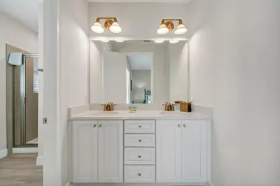 a white bathroom with a sink and a mirror at The Lime Life Cottage Near Disney With Margaritaville Resort And Island H20 Waterpark Access - 8056Sh in Orlando