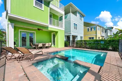 a swimming pool in front of a house at The Lime Life Cottage Near Disney With Margaritaville Resort And Island H20 Waterpark Access - 8056Sh in Orlando
