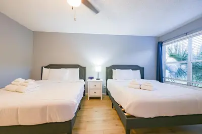 two twin beds in a room with a window at Disney Universal Family Resort # Pool # Gym in Orlando