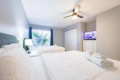 a bedroom with a white bed and a ceiling fan at Disney Universal Family Resort # Pool # Gym in Orlando