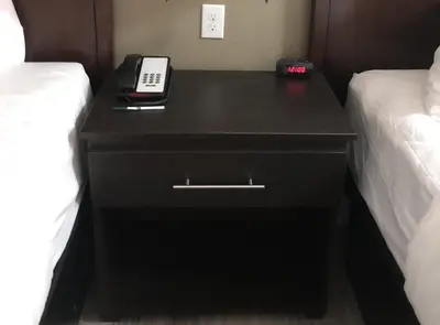 a black nightstand with a phone on it next to two beds at Green Palms Extended Stay in Kissimmee