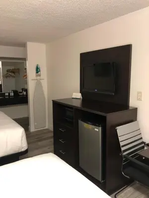 a hotel room with a flat screen tv and a bed at Green Palms Extended Stay in Kissimmee