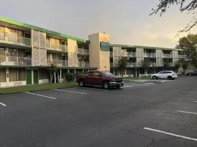 a red truck parked in a parking lot in front of a building at Green Palms Extended Stay in Kissimmee