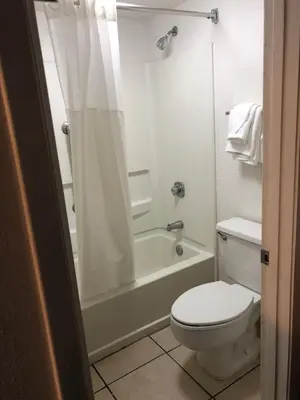 a bathroom with a toilet and a tub and a shower at Green Palms Extended Stay in Kissimmee