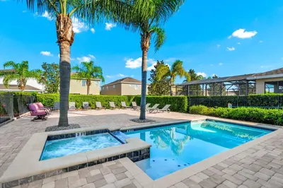 a swimming pool with palm trees in a yard at Home With Movie Theater, Game & Theme Room Near Disney With Resort & Waterpark Access - 7621Wi in Orlando
