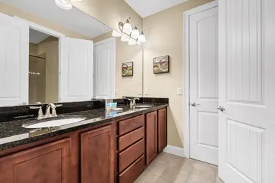 a bathroom with two sinks and a large mirror at Home With Movie Theater, Game & Theme Room Near Disney With Resort & Waterpark Access - 7621Wi in Orlando