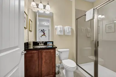 a bathroom with a toilet and a sink and a shower at Home With Movie Theater, Game & Theme Room Near Disney With Resort & Waterpark Access - 7621Wi in Orlando