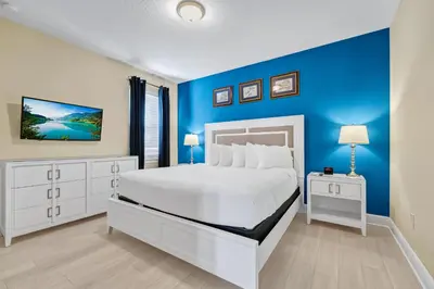 a bedroom with a white bed and a blue wall at Home With Movie Theater, Game & Theme Room Near Disney With Resort & Waterpark Access - 7621Wi in Orlando