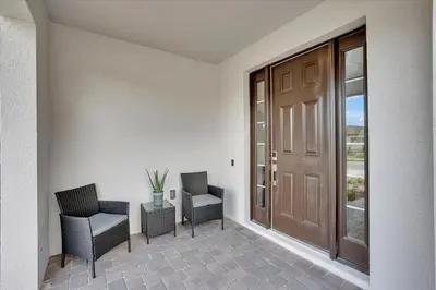 a hallway with two chairs and a door with a window at Charming 4 Bdr Villa near Disney in Kissimmee