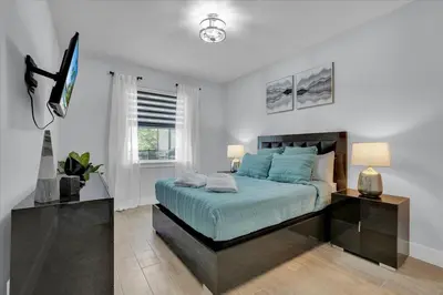 a bedroom with a bed and a flat screen tv at Charming 4 Bdr Villa near Disney in Kissimmee