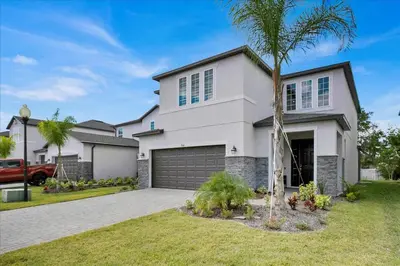 a white house with a palm tree in front of it at Charming 4 Bdr Villa near Disney in Kissimmee