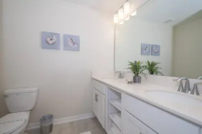 a bathroom with two sinks and a toilet and a mirror at C4731-203-Storey Lake Resort Near Disney-Universal in Kissimmee