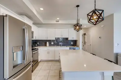 a kitchen with white cabinets and a large island at C4731-203-Storey Lake Resort Near Disney-Universal in Kissimmee