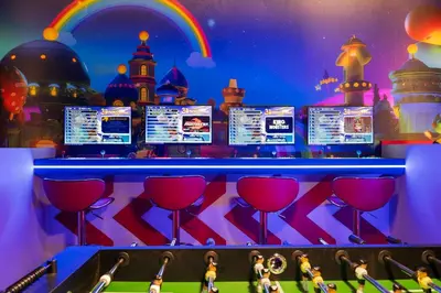 a bar with a bunch of computer screens and red wine glasses at Orlando Paradise 5BR Themed Home in Orlando
