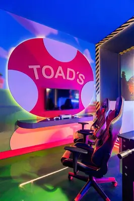 a table and chairs in a room with a toads sign at Orlando Paradise 5BR Themed Home in Orlando