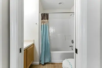 a bathroom with a tub and a shower curtain at Vila 4Q com Piscina Privativa – Lake Berkley in Kissimmee