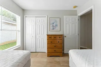 a bedroom with two beds and a wooden dresser at Vila 4Q com Piscina Privativa – Lake Berkley in Kissimmee