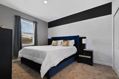 a bedroom with a blue and white bed and a window at Casa 9Q em Resort c/ Piscina – 11km da Disney in Kissimmee