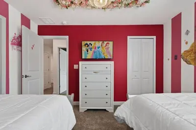 a bedroom with red walls and a dresser with a tv at Casa 9Q em Resort c/ Piscina – 11km da Disney in Kissimmee