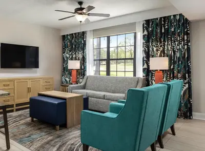 a living room with a couch and chairs and a tv at Weekly rental at Orange Lake Resort for a family of 8 people in Orlando
