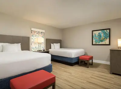a hotel room with two beds and a red stool at Weekly rental at Orange Lake Resort for a family of 8 people in Orlando