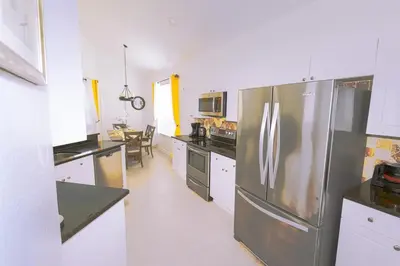 a kitchen with a stainless steel refrigerator and white cabinets at Spacious Home Perfect for Big Families in Kissimmee