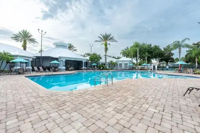 a swimming pool at a resort with palm trees at Spacious Home Perfect for Big Families in Kissimmee