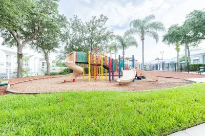 a playground with a slide in a park at Spacious Home Perfect for Big Families in Kissimmee
